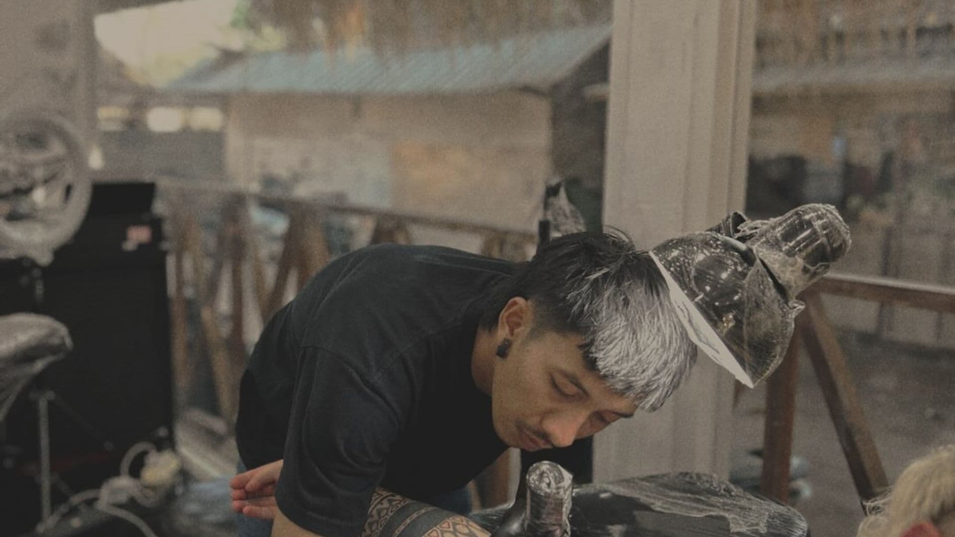 MG sedang menato klien di studio